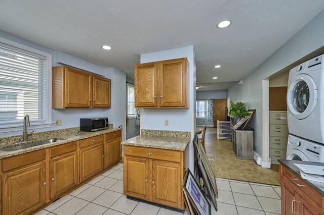 15 Hamilton St, Boston, MA 02136 - kitchen featuring stacked washer / dryer, stainless steel microwave, brown cabinetry, light tile patterned flooring, and recessed lighting