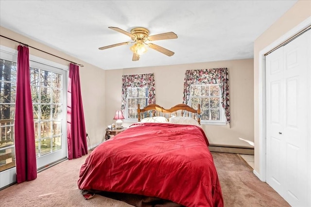 carpeted bedroom with ceiling fan, access to exterior, baseboard heating, and a closet