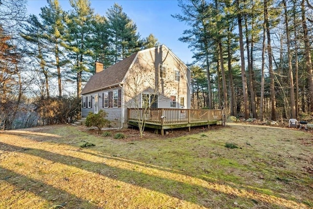 exterior space with a wooden deck and a lawn