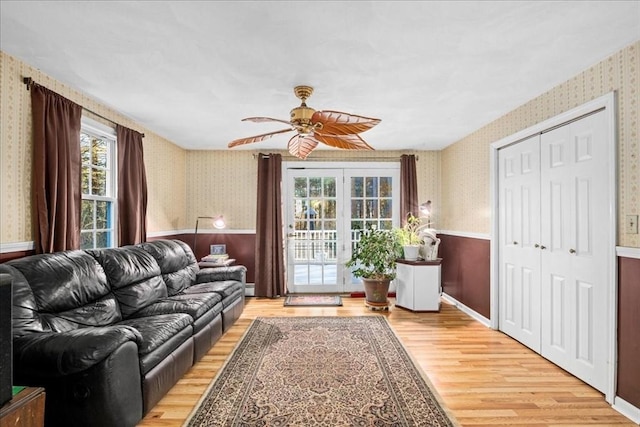 living room featuring ceiling fan, french doors, a baseboard radiator, and light hardwood / wood-style flooring