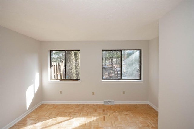 spare room with visible vents, a healthy amount of sunlight, and baseboards