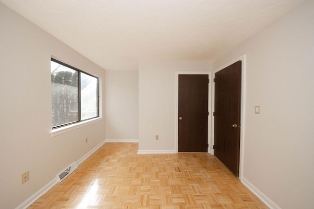 unfurnished room with visible vents and baseboards