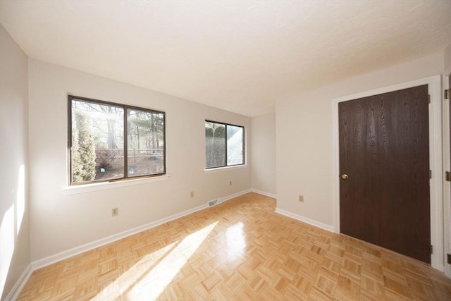 spare room featuring visible vents and baseboards