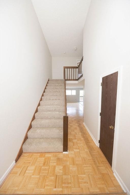 stairs with a high ceiling and baseboards