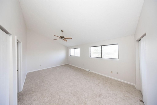 unfurnished room with light colored carpet, baseboards, lofted ceiling, and a ceiling fan