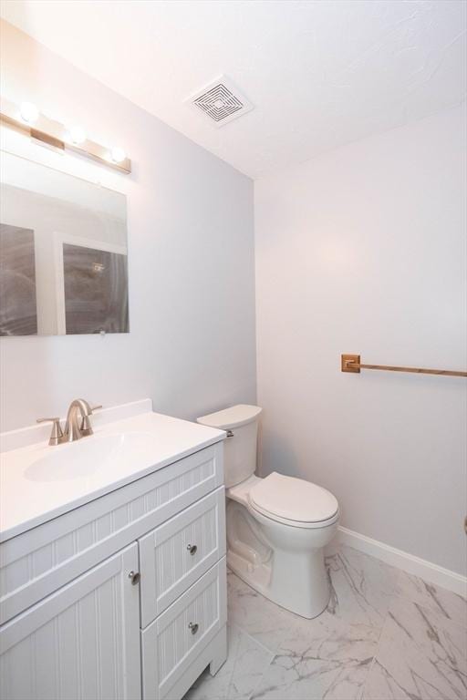 bathroom featuring visible vents, toilet, marble finish floor, baseboards, and vanity