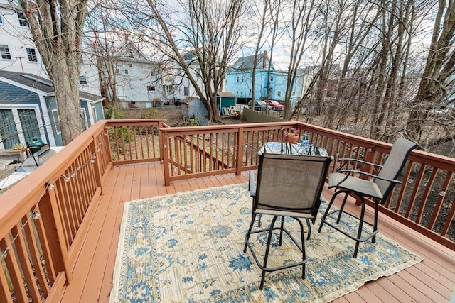 wooden deck with a residential view and outdoor dining area