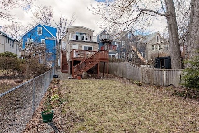 back of house featuring a fenced backyard, stairway, a residential view, and a balcony