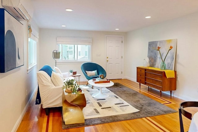 living area featuring a wall mounted AC, recessed lighting, wood finished floors, and baseboards