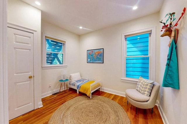 living area with wood finished floors, baseboards, and recessed lighting
