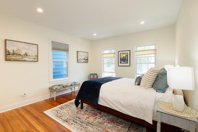 bedroom with wood finished floors, baseboards, and recessed lighting