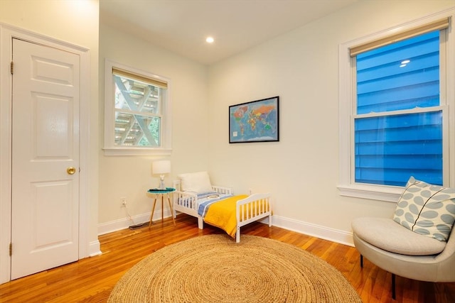 bedroom with baseboards, wood finished floors, and recessed lighting