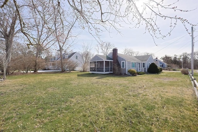 view of green lawn featuring a sunroom