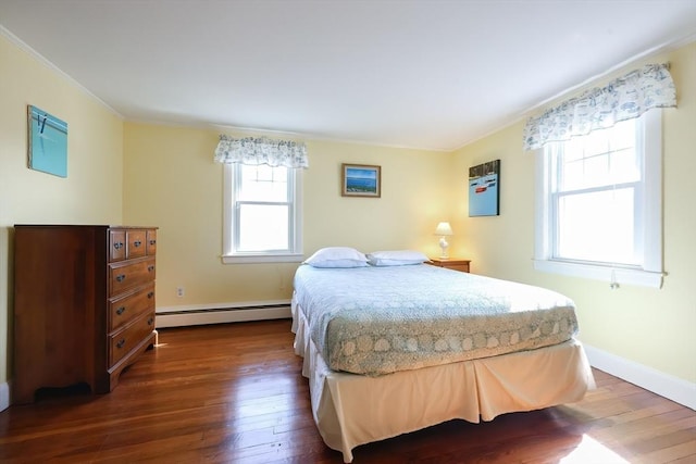 bedroom featuring a baseboard heating unit, ornamental molding, dark wood-style flooring, and baseboards