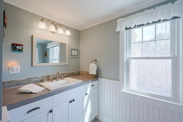 bathroom with a wainscoted wall, vanity, and crown molding
