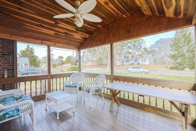 sunroom featuring lofted ceiling and a ceiling fan