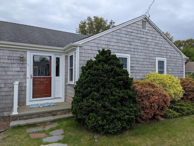 entrance to property featuring roof with shingles