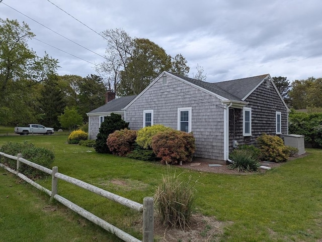 view of home's exterior with a chimney and roof with shingles