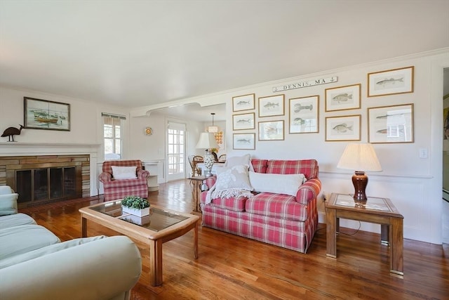living room with ornamental molding, wood finished floors, and a fireplace