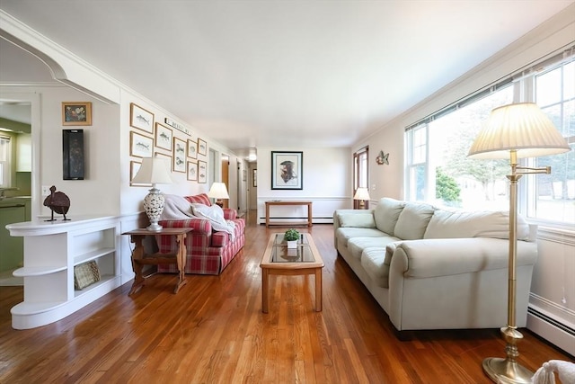living room with baseboard heating, wood finished floors, and a baseboard heating unit