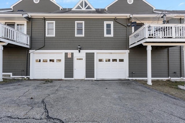 rear view of house featuring an attached garage and driveway