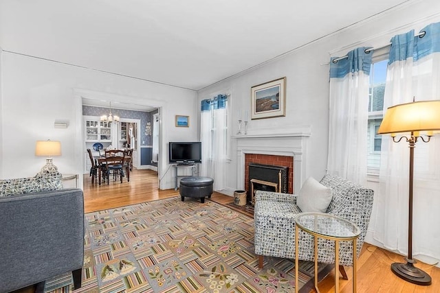 86 Glencoe St Unit 86, Boston, MA 02135 - living room featuring a chandelier, wood finished floors, a fireplace, and ornamental molding