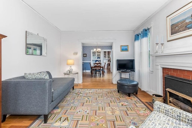 86 Glencoe St Unit 86, Boston, MA 02135 - living area featuring a fireplace, a chandelier, crown molding, wood finished floors, and baseboards