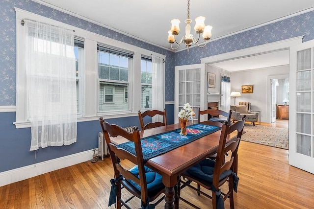86 Glencoe St Unit 86, Boston, MA 02135 - dining room featuring wallpapered walls, wood finished floors, baseboards, a chandelier, and ornamental molding