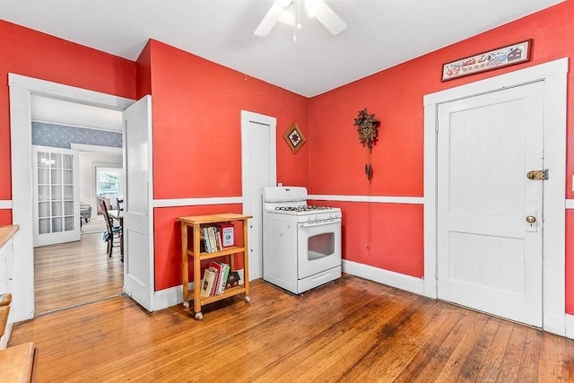 86 Glencoe St Unit 86, Boston, MA 02135 - kitchen with white gas range oven, wood finished floors, a ceiling fan, and baseboards