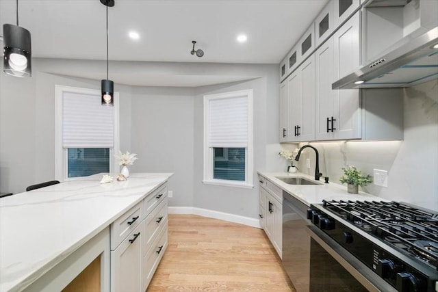 755 Boylston St Unit 1, Brookline, MA 02467 - kitchen featuring stainless steel appliances, wall chimney exhaust hood, a sink, light wood-style floors, and baseboards