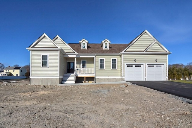 view of front of home featuring driveway, covered porch, a shingled roof, and a garage