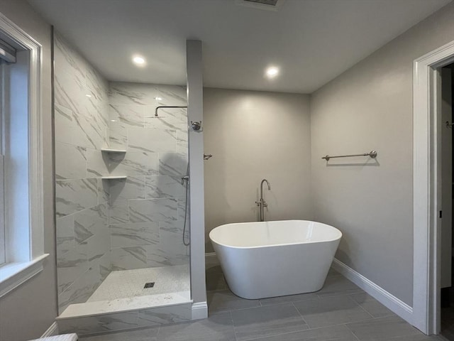 bathroom with marble finish floor, a marble finish shower, recessed lighting, a freestanding tub, and baseboards