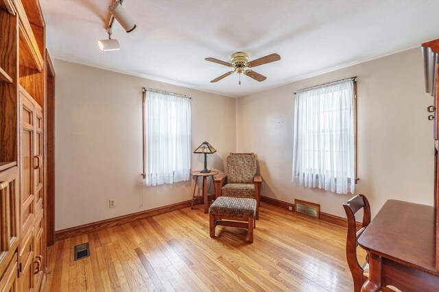 sitting room with plenty of natural light, a ceiling fan, visible vents, and light wood-style floors