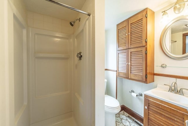 full bath with vanity, a shower stall, and toilet