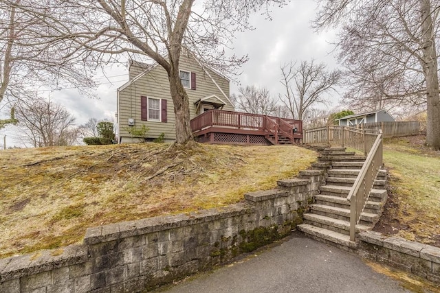 view of side of home with stairs, fence, and a deck