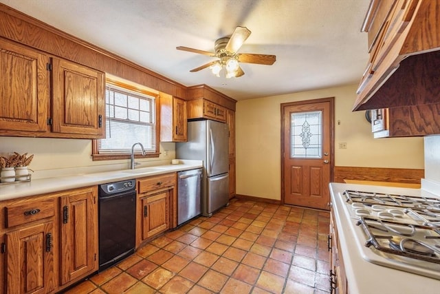 kitchen featuring brown cabinetry, ceiling fan, stainless steel appliances, and a sink