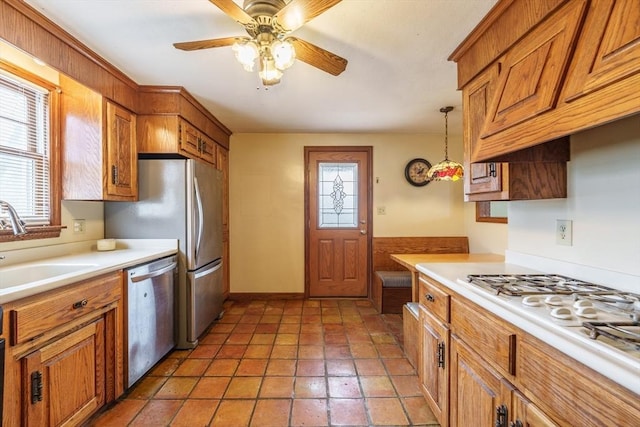 kitchen featuring dishwasher, brown cabinets, a sink, and light countertops