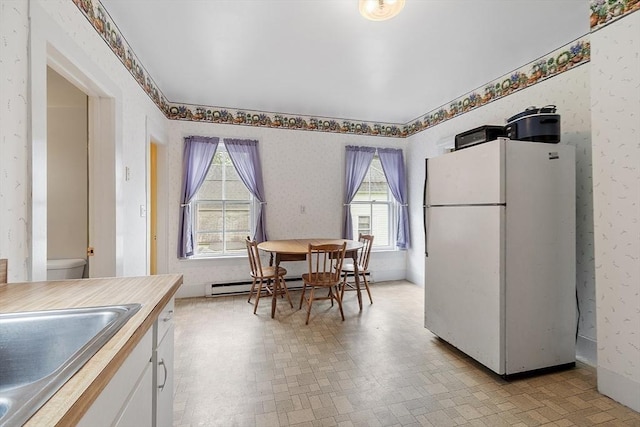 98 Mechanic St, Orange, MA 01364 - kitchen with freestanding refrigerator, white cabinetry, wallpapered walls, and light countertops