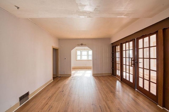 unfurnished room with light hardwood / wood-style flooring and french doors