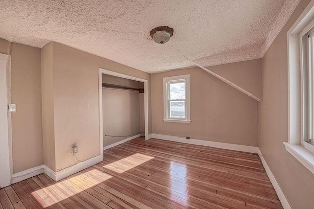 unfurnished bedroom with hardwood / wood-style flooring, a textured ceiling, and a closet