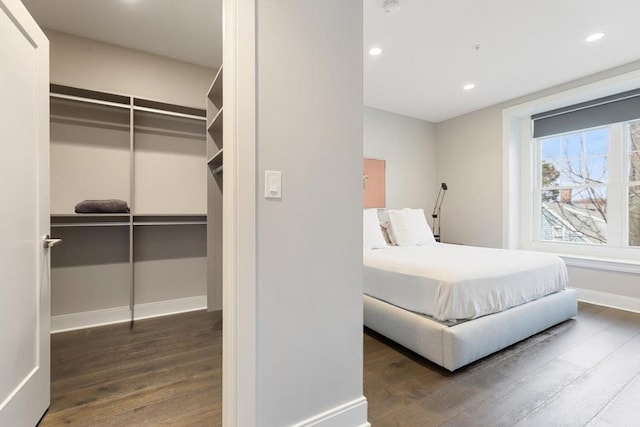 bedroom with a closet, recessed lighting, baseboards, and wood finished floors