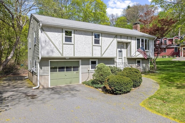 62 Brook St, Wakefield, MA 01880 - bi-level home featuring a chimney, an attached garage, asphalt driveway, and a front lawn