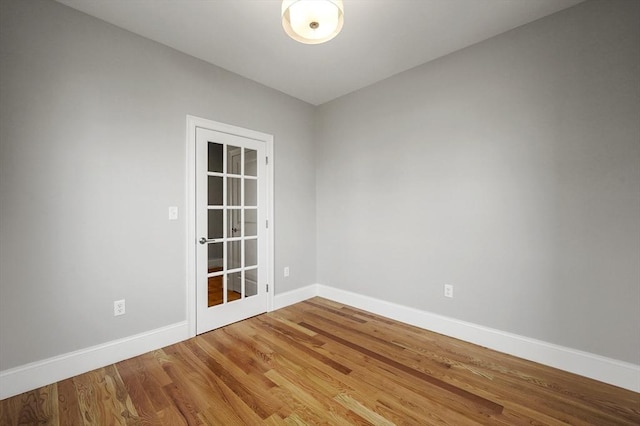 spare room featuring wood finished floors and baseboards