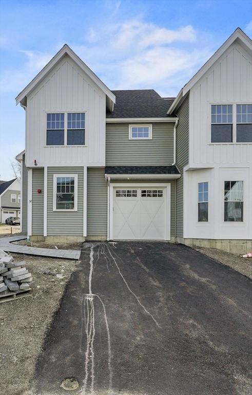 view of front of home with a garage, board and batten siding, a shingled roof, and aphalt driveway