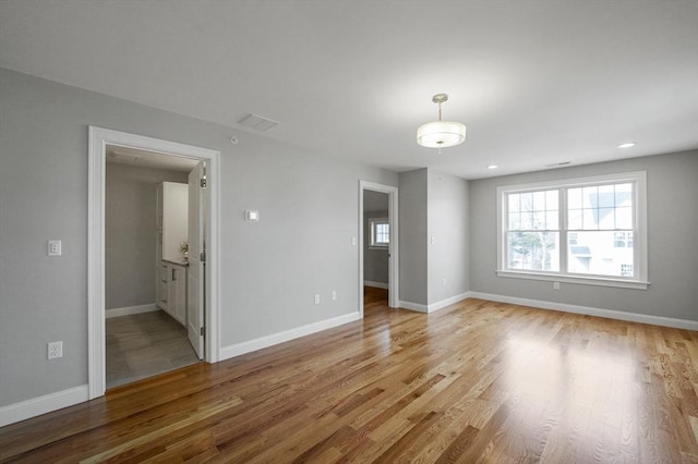 spare room with recessed lighting, baseboards, and light wood finished floors