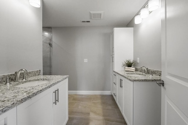 full bathroom featuring visible vents, two vanities, baseboards, and a sink