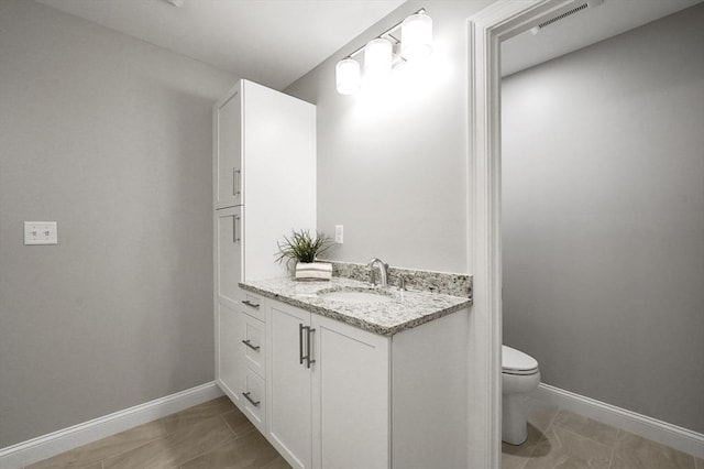 bathroom featuring tile patterned flooring, visible vents, baseboards, toilet, and vanity