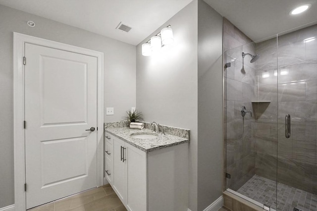 bathroom with vanity, a shower stall, and visible vents