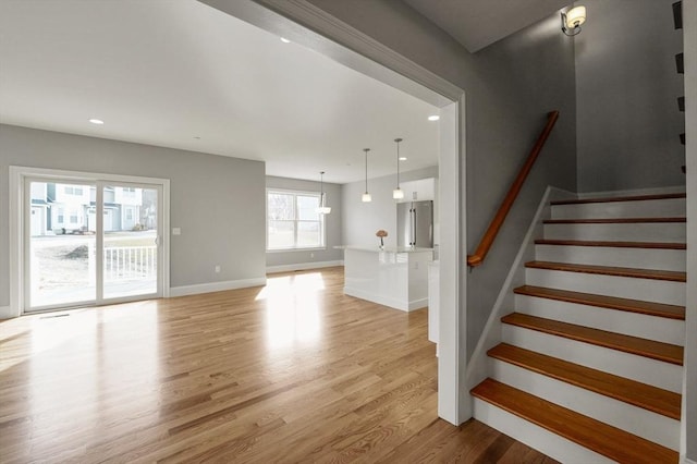 stairway with recessed lighting, baseboards, and wood finished floors