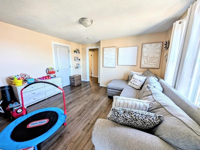 living area with a textured ceiling, baseboards, and wood finished floors